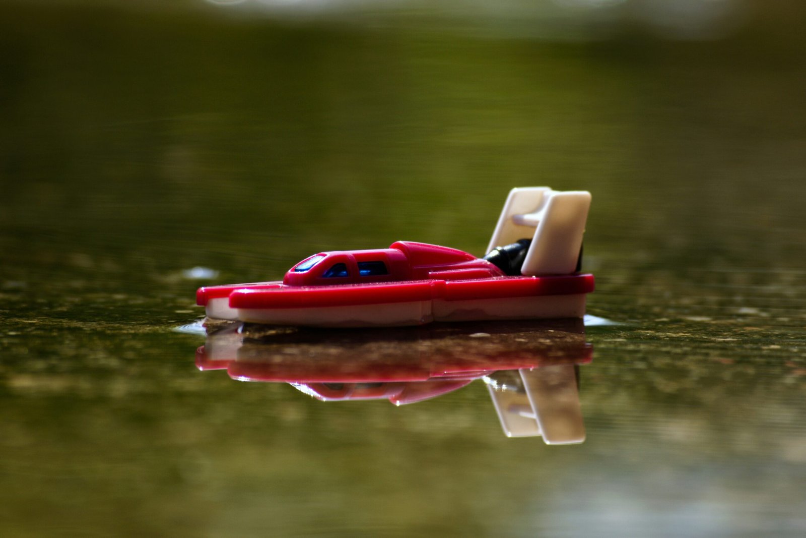 red and white plastic boat on water